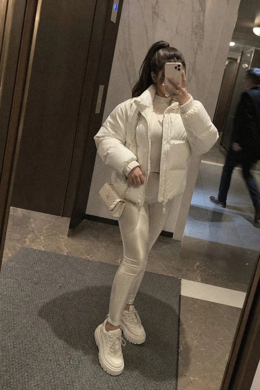 white cropped puffer jacket ivory leather leggings white chunky sneakers cream chain crossbody white christmas outfit 10