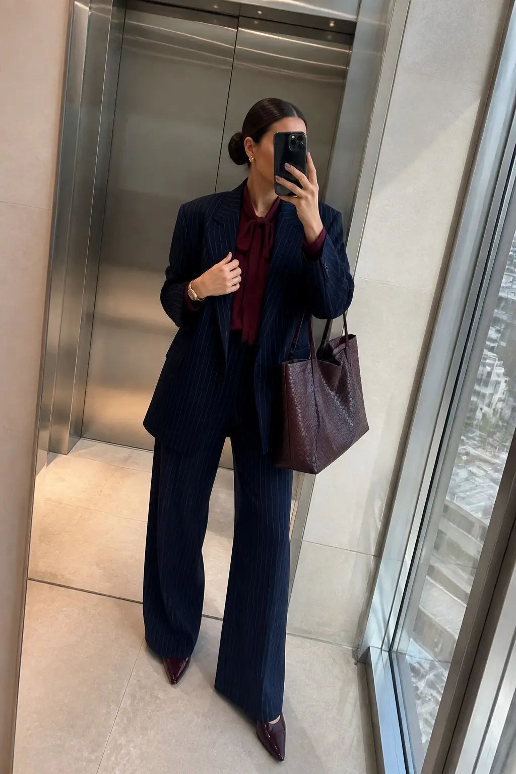 navy pinstripe oversized blazer navy pinstripe wide leg trousers burgundy pussy bow blouse burgundy pointed toe pumps burgundy woven tote bag gold watch small earrings outfit 21