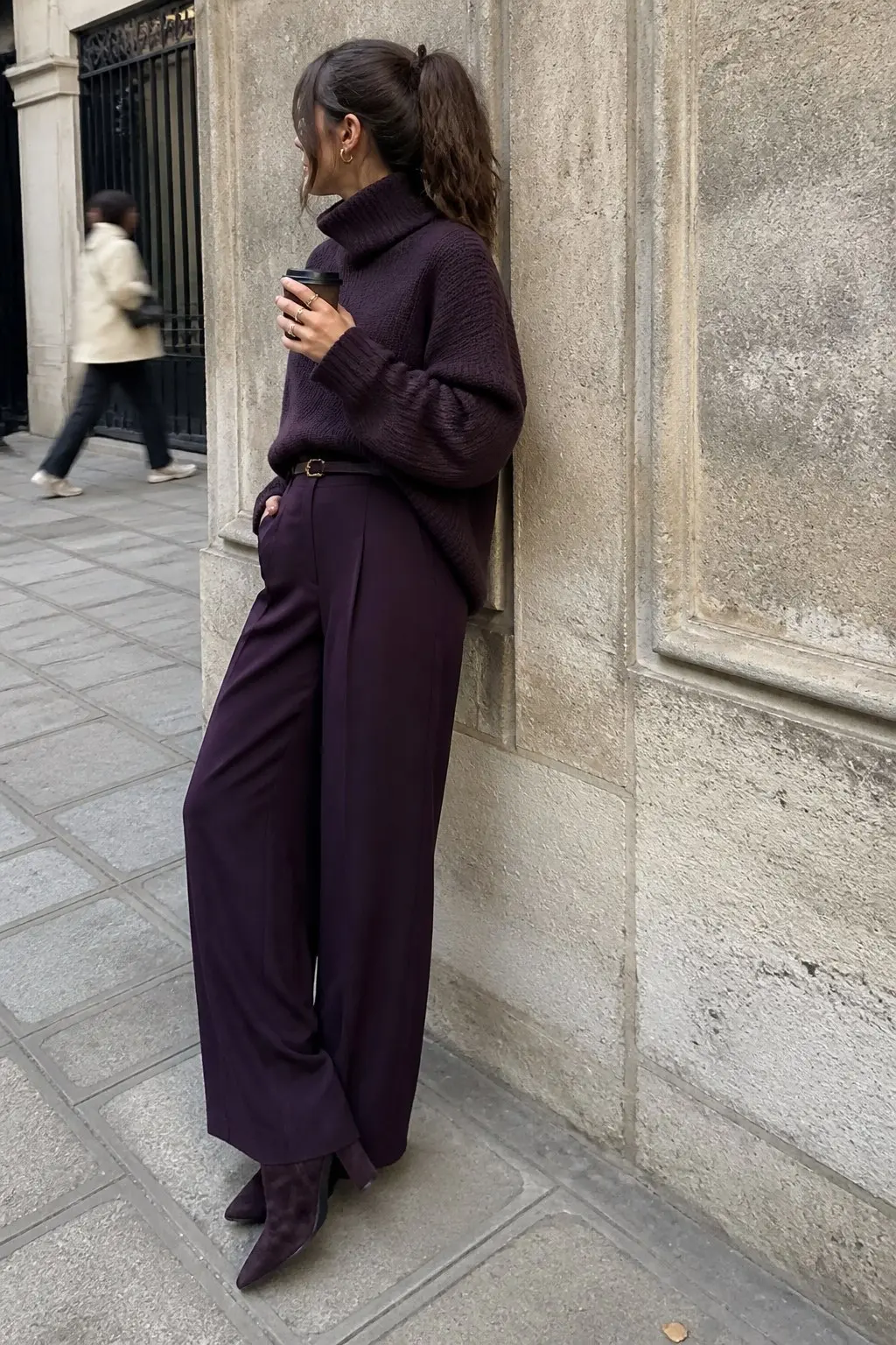 plum oversized turtleneck knit sweater with plum wide-leg tailored trousers thin brown belt plum suede ankle boots and gold hoop earrings monochrome outfit 3