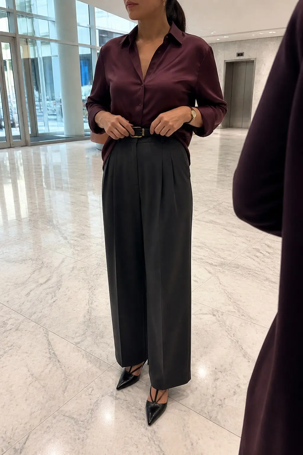 plum satin button-down shirt tucked into charcoal wide-leg pleated trousers with black leather belt black pointed strappy slingback heels and gold watch outfit 6
