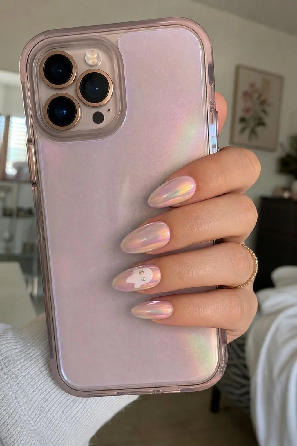 medium almond nails with milky pink aurora chrome holographic shimmer base, white ghost with rhinestone crystal eyes on ring finger accent nail, nail look 5