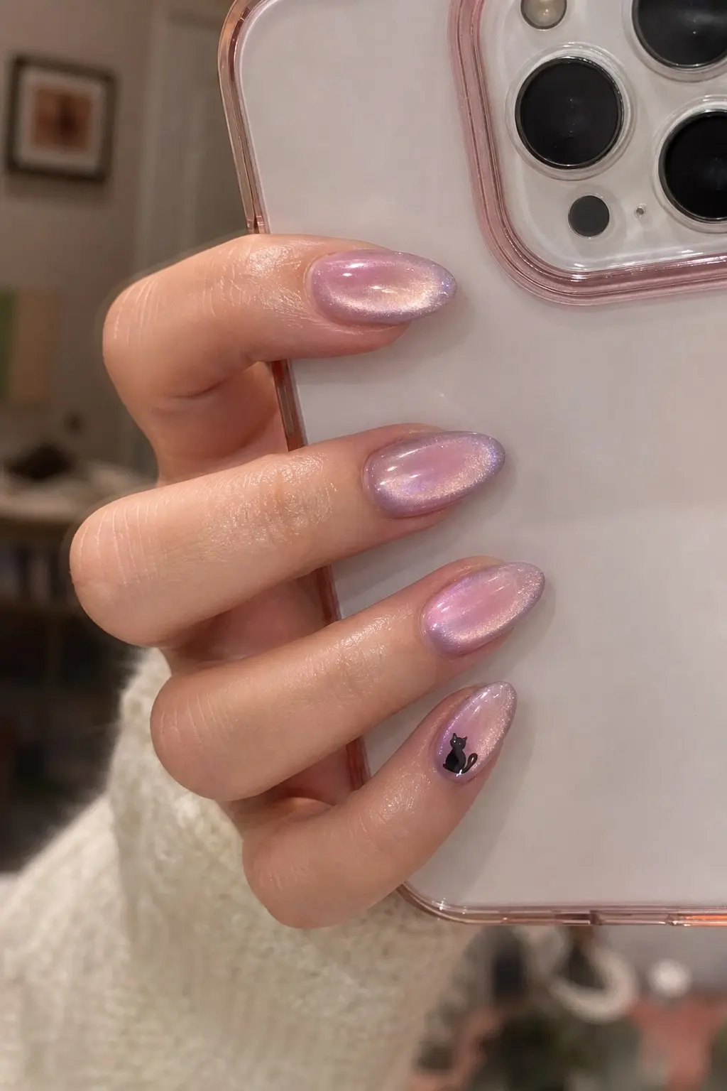 medium almond nails with iridescent pink-to-lavender cat eye magnetic gel finish, tiny black cat silhouette on pinky accent nail, nail look 15