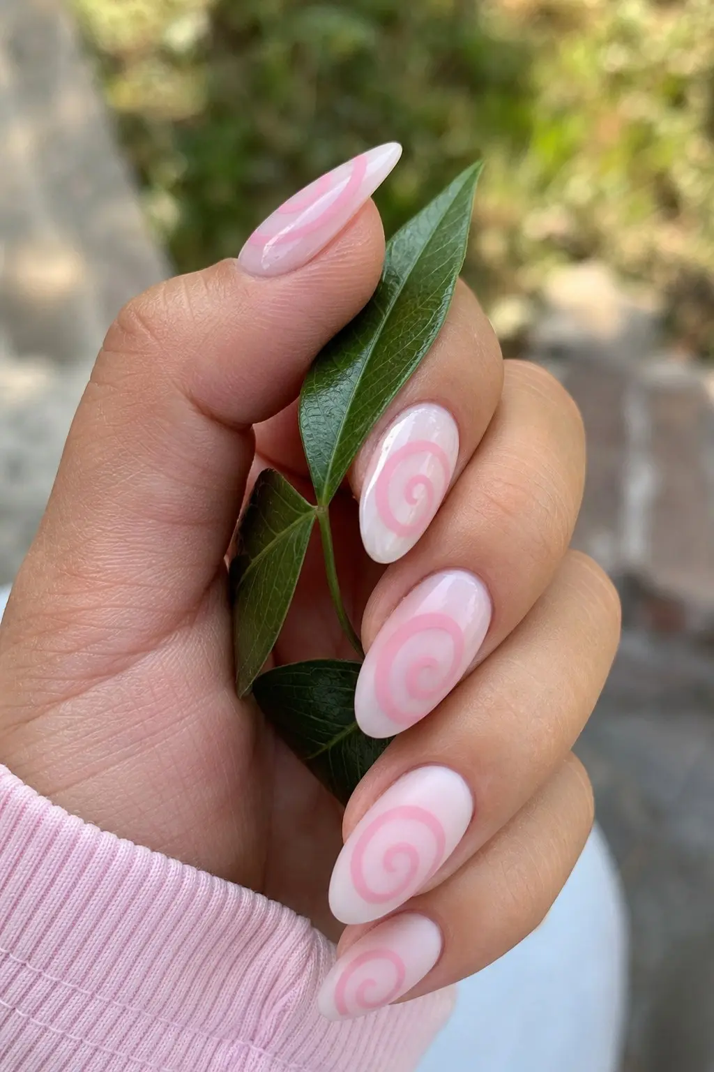 medium almond nails with milky white sheer base and pink swirl spiral design on all nails, glossy finish, nail look 19