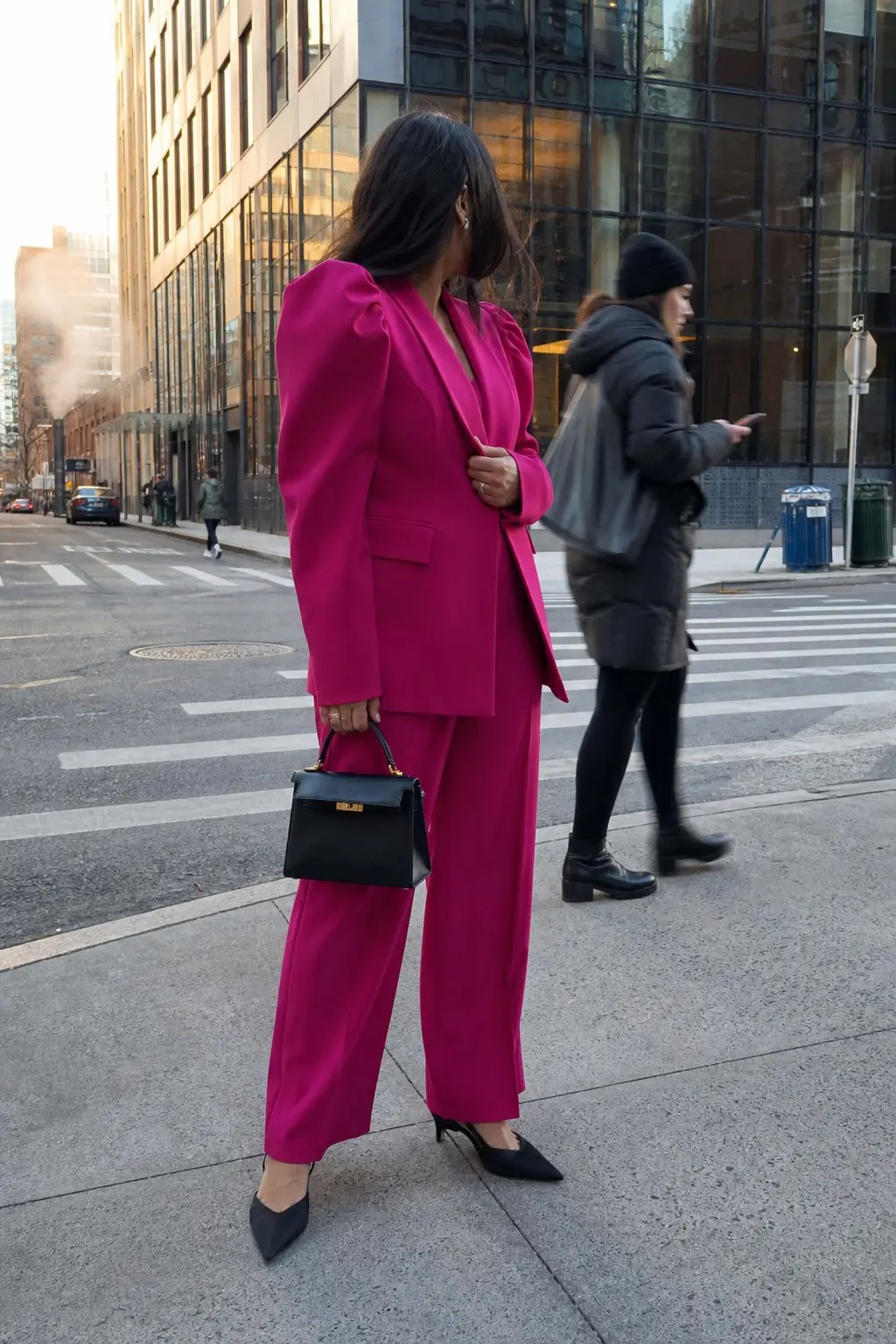 woman in fuchsia puff shoulder blazer matching wide leg trousers black pointed toe pumps small black top handle structured bag small stud earrings outfit 12