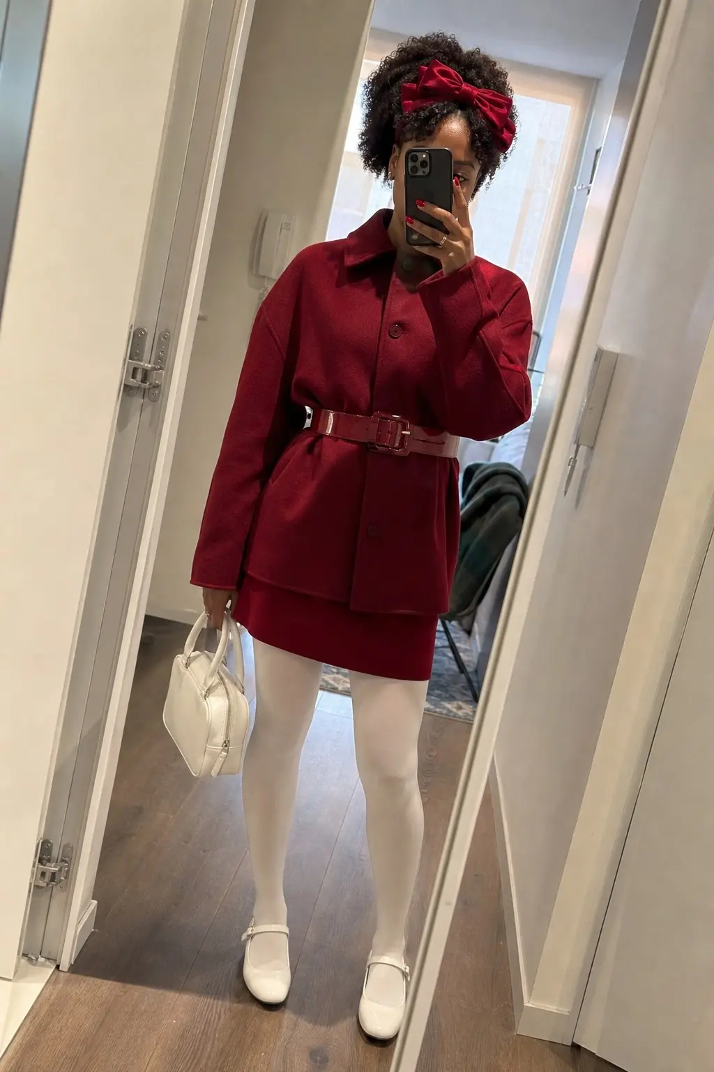 woman in red boxy wool jacket red mini skirt red patent leather wide belt white opaque tights white mary jane flats white mini top handle bag red hair bow outfit 24