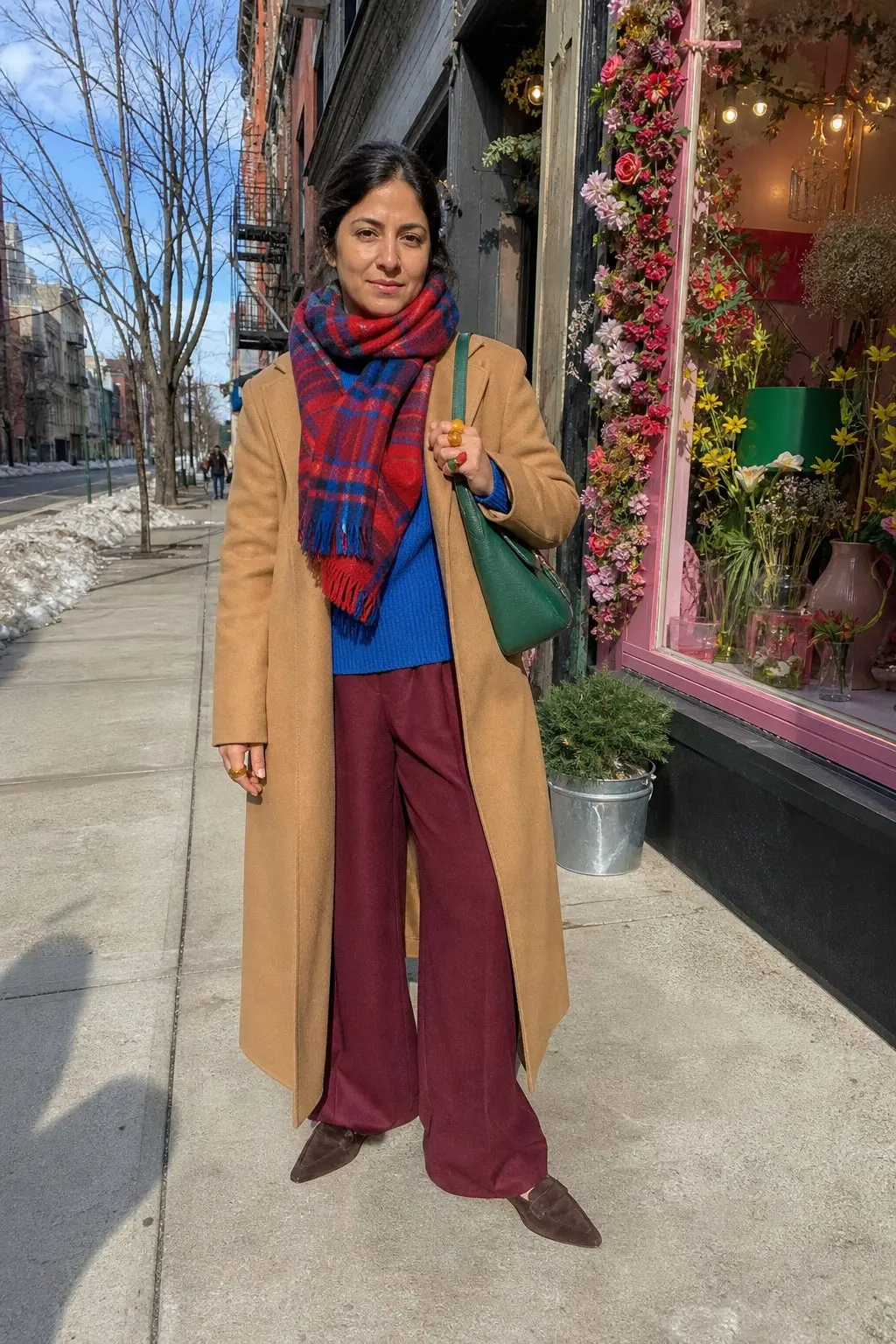 camel wool longline coat blue chunky knit sweater burgundy wide-leg trousers red blue plaid fringe scarf green leather shoulder bag dark brown suede loafers gold resin ring outfit 25