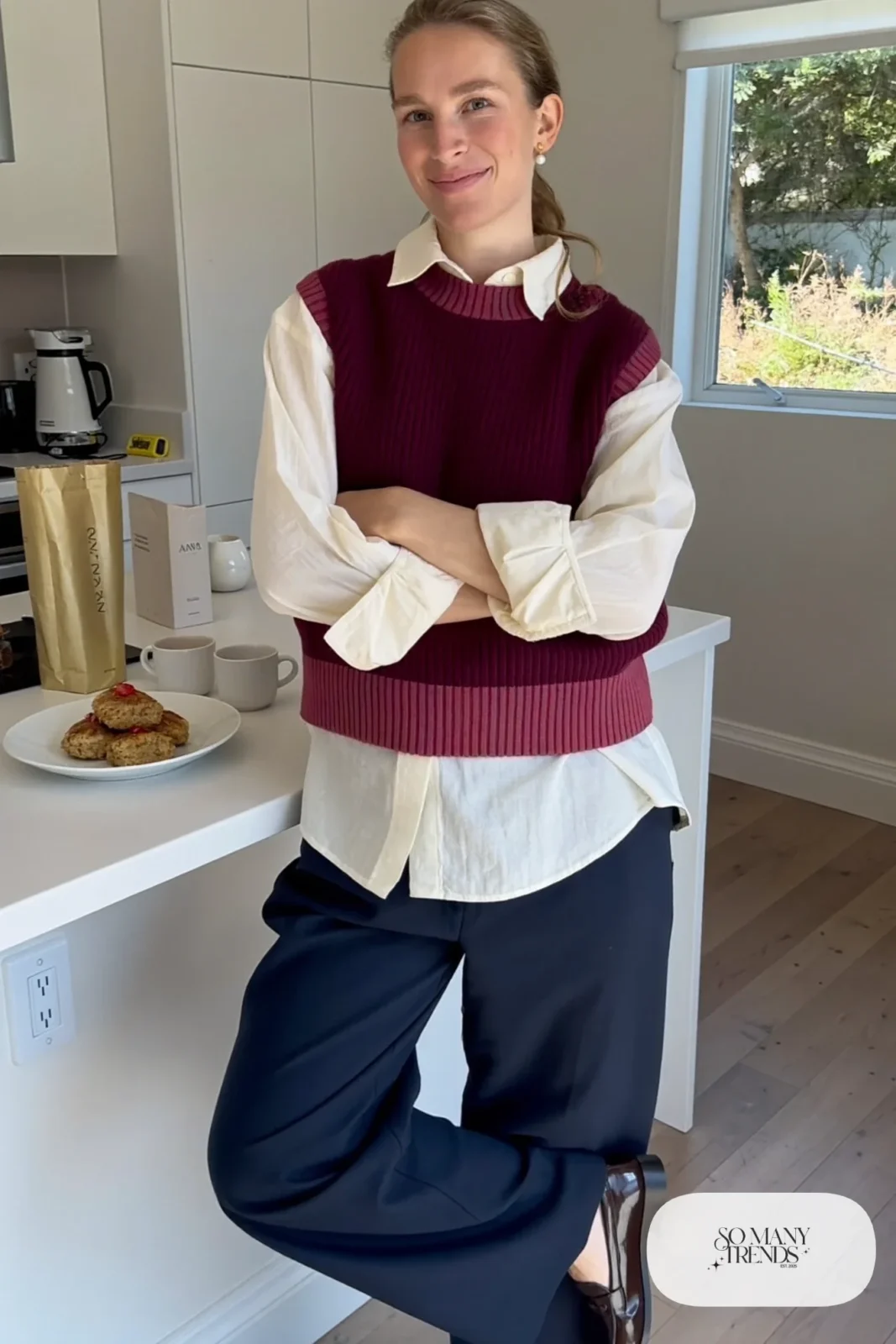 pregnant woman in plum ribbed knit vest over cream poplin blouse, navy wide leg trousers, dark loafers, pearl stud earrings, shirt cuffs visible, outfit 6