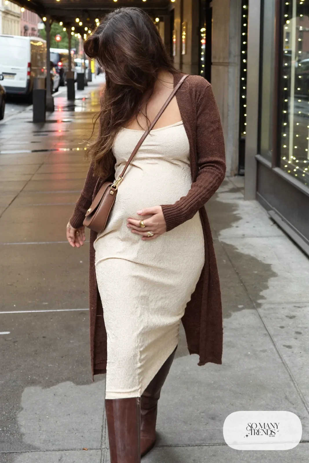 pregnant woman in cream broderie anglaise midi dress, chocolate brown long cardigan, brown knee high boots, stacked gold rings, brown leather crossbody, tortoiseshell hair clip, outfit 12