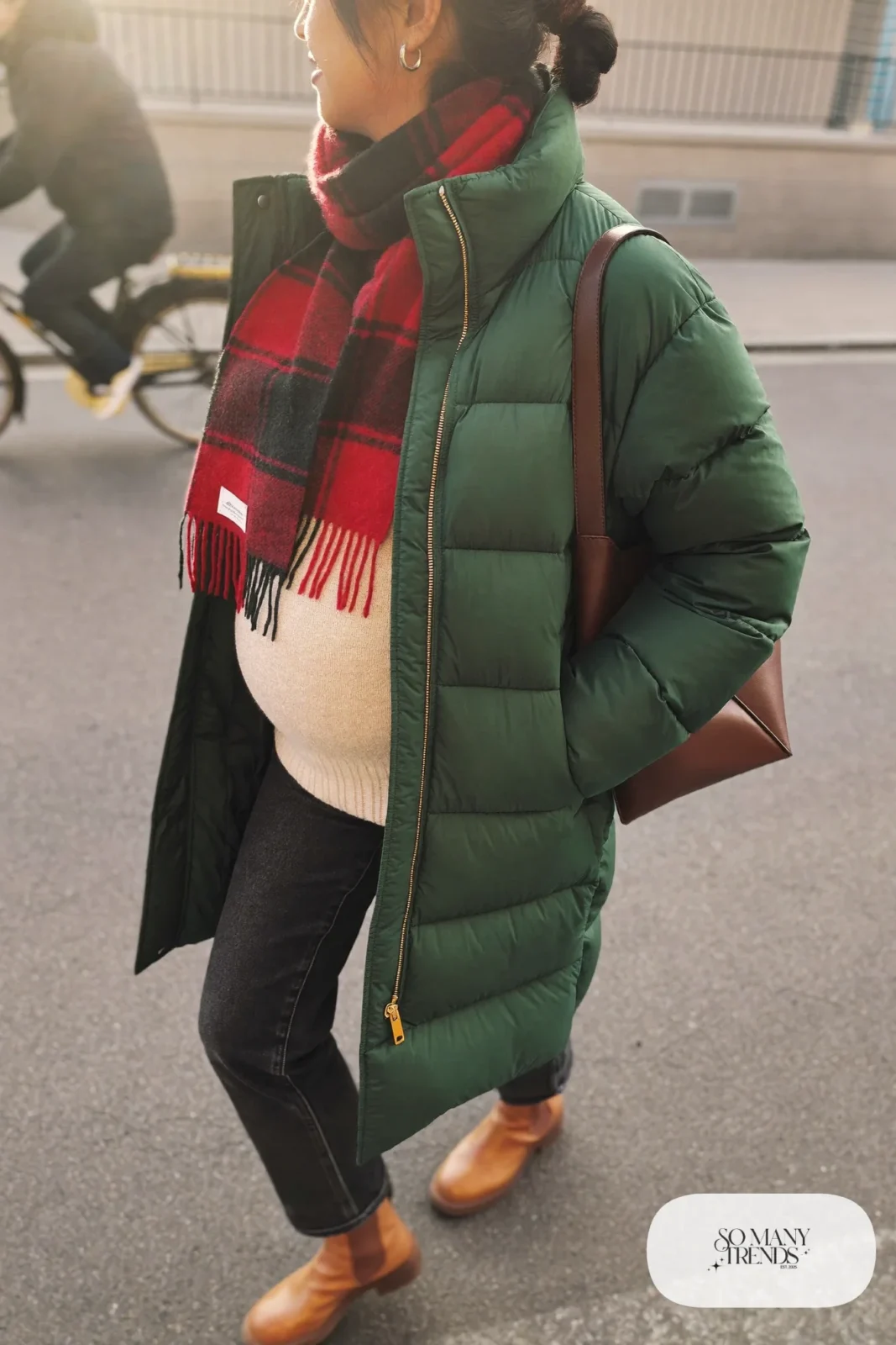pregnant woman in forest green longline quilted puffer coat, cream chunky knit, dark maternity jeans, camel Chelsea boots, plaid green red scarf at neck, brown leather bucket bag, outfit 24