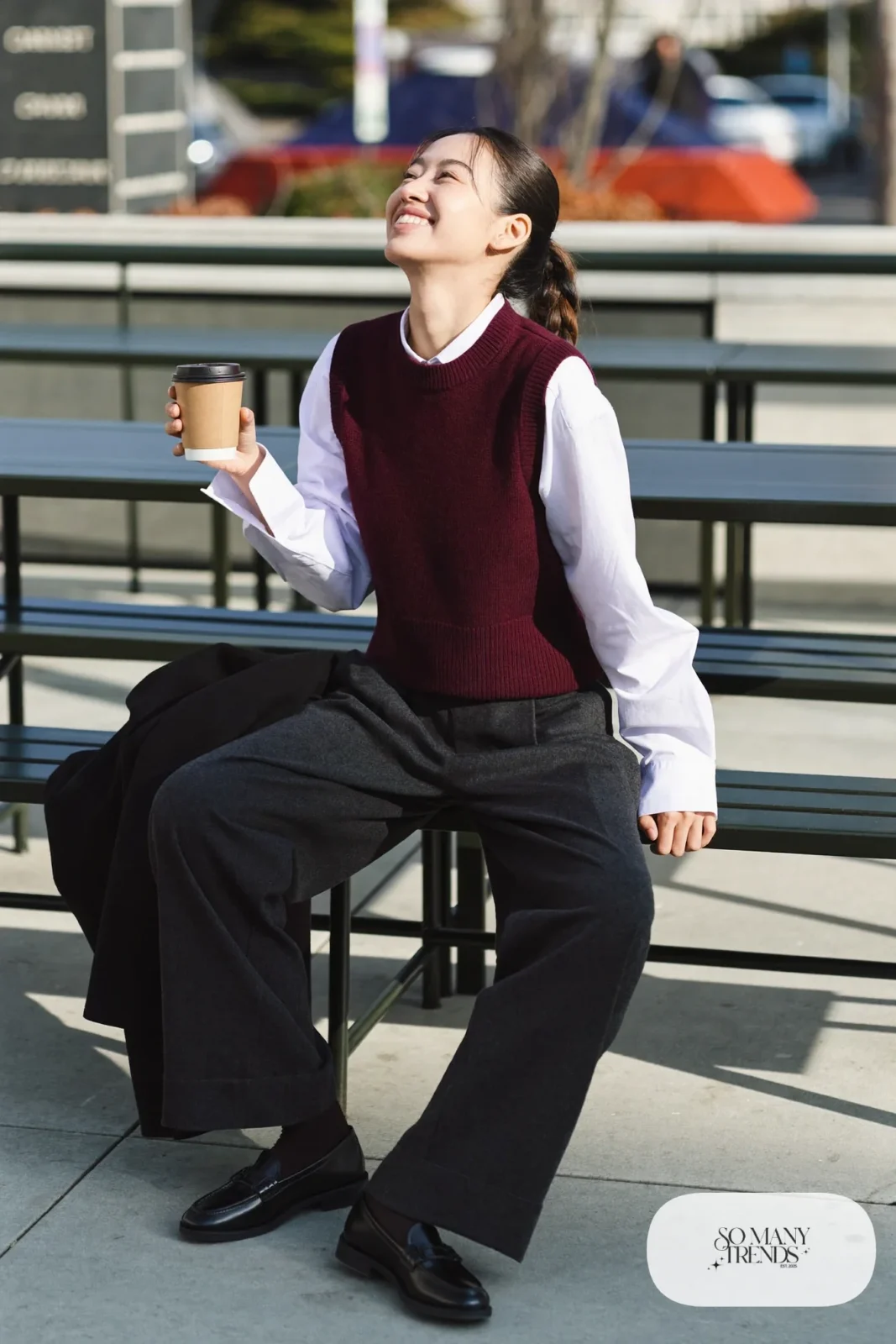 burgundy knit vest white poplin shirt charcoal wide-leg trousers black loafers black overcoat outfit 3