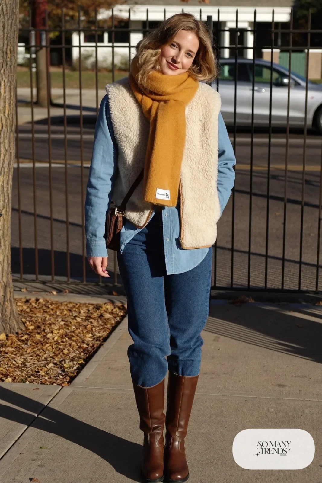 light denim shirt dark jeans cream sherpa vest brown leather boots mustard scarf outfit 29