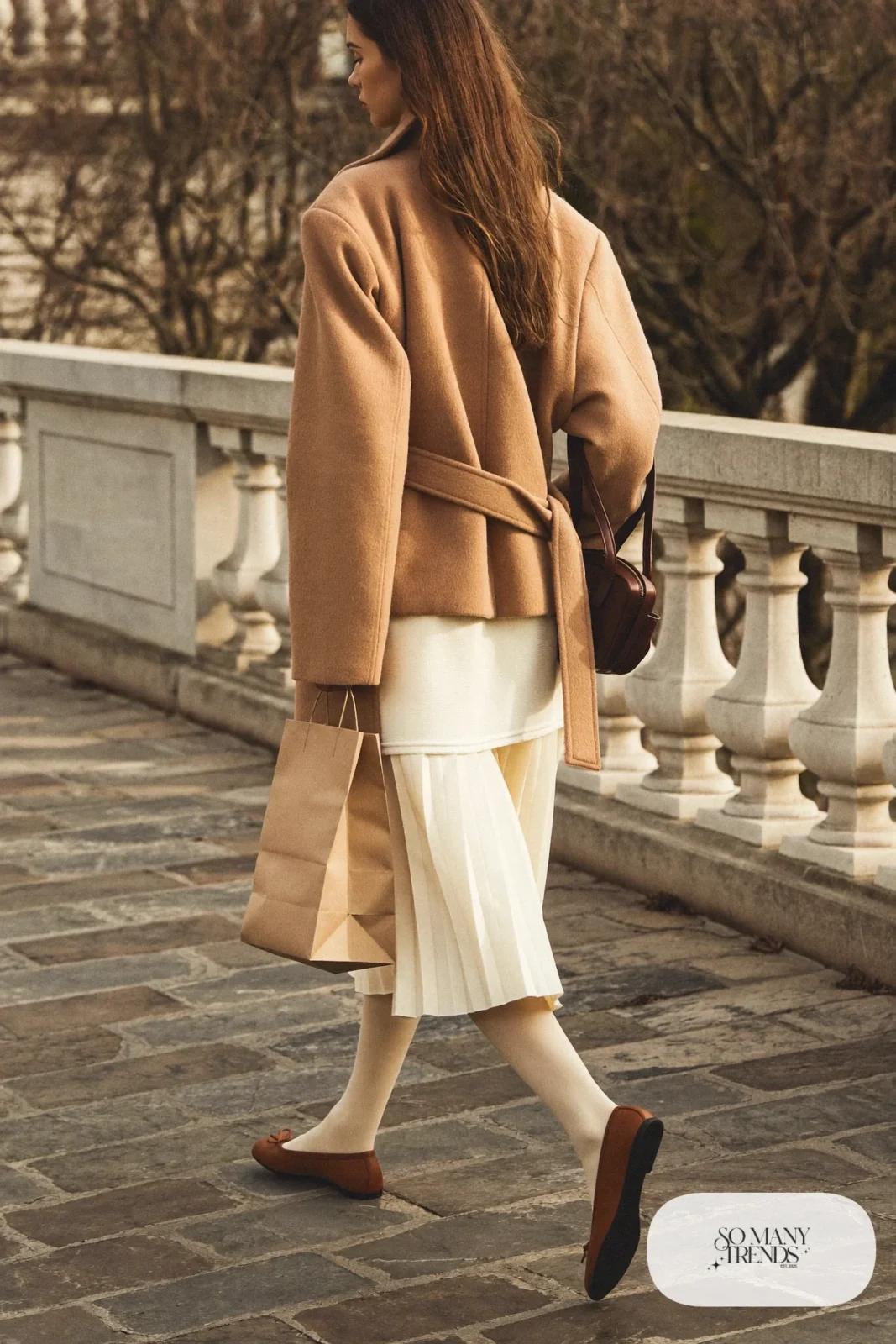 long camel wrap coat, cream knit top, ivory pleated skirt, brown flats, sheer tights, outfit 16