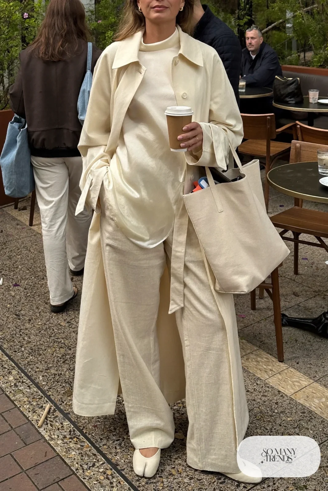 woman in cream trench coat, linen pants, silk shell and flats outfit 13