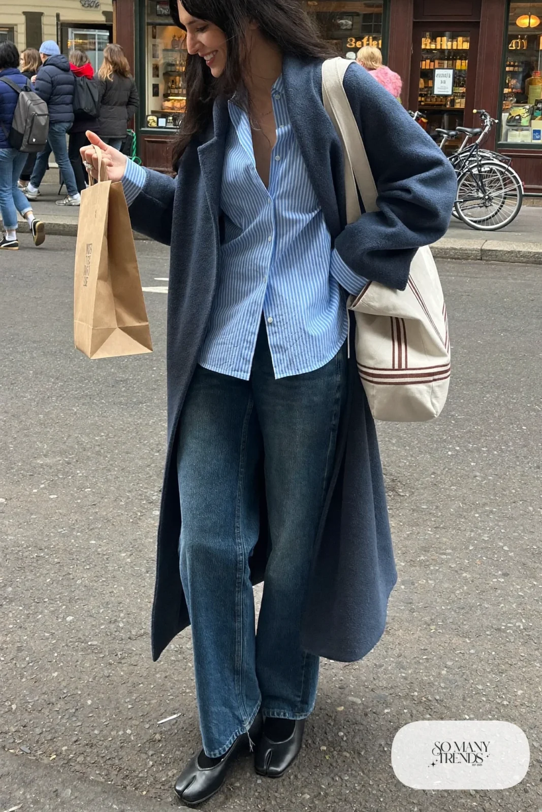 navy long wool coat striped button-up shirt straight leg jeans black ballet flats tote bag outfit 5
