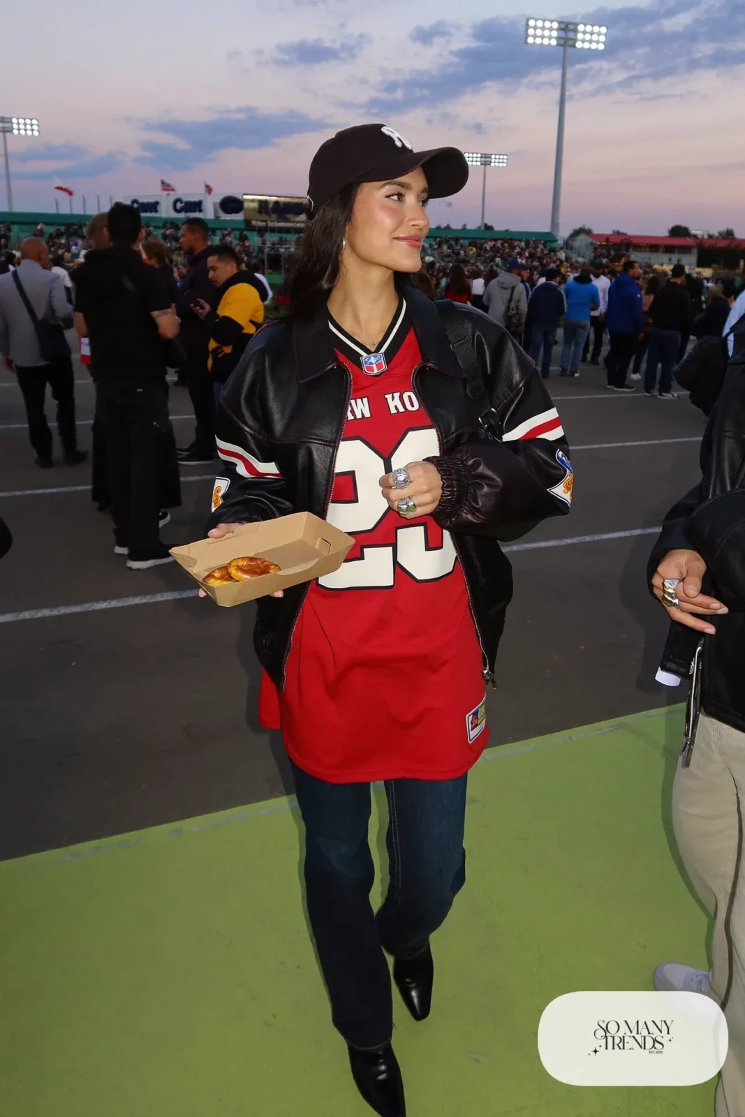 red football jersey black leather jacket dark straight jeans black ankle boots black cap outfit 5