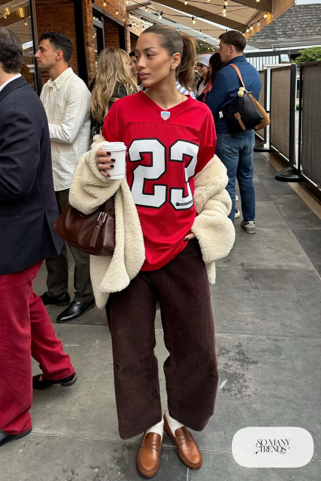 red football jersey wide leg brown corduroy pants cream sherpa jacket brown loafers outfit 12