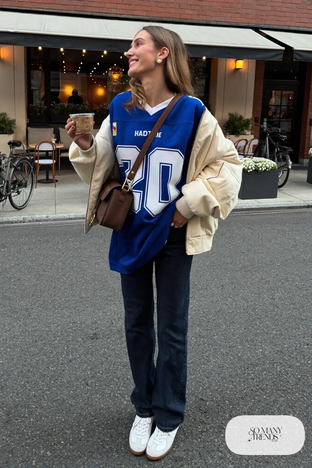 cobalt football jersey dark straight jeans cream bomber jacket leather sneakers gold studs outfit 26