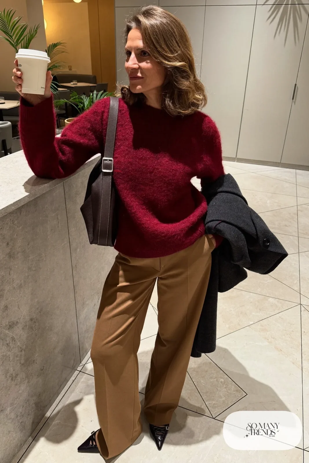 burgundy merino sweater camel wide-leg pants black pointed flats long charcoal coat over arm tote bag office outfit 4