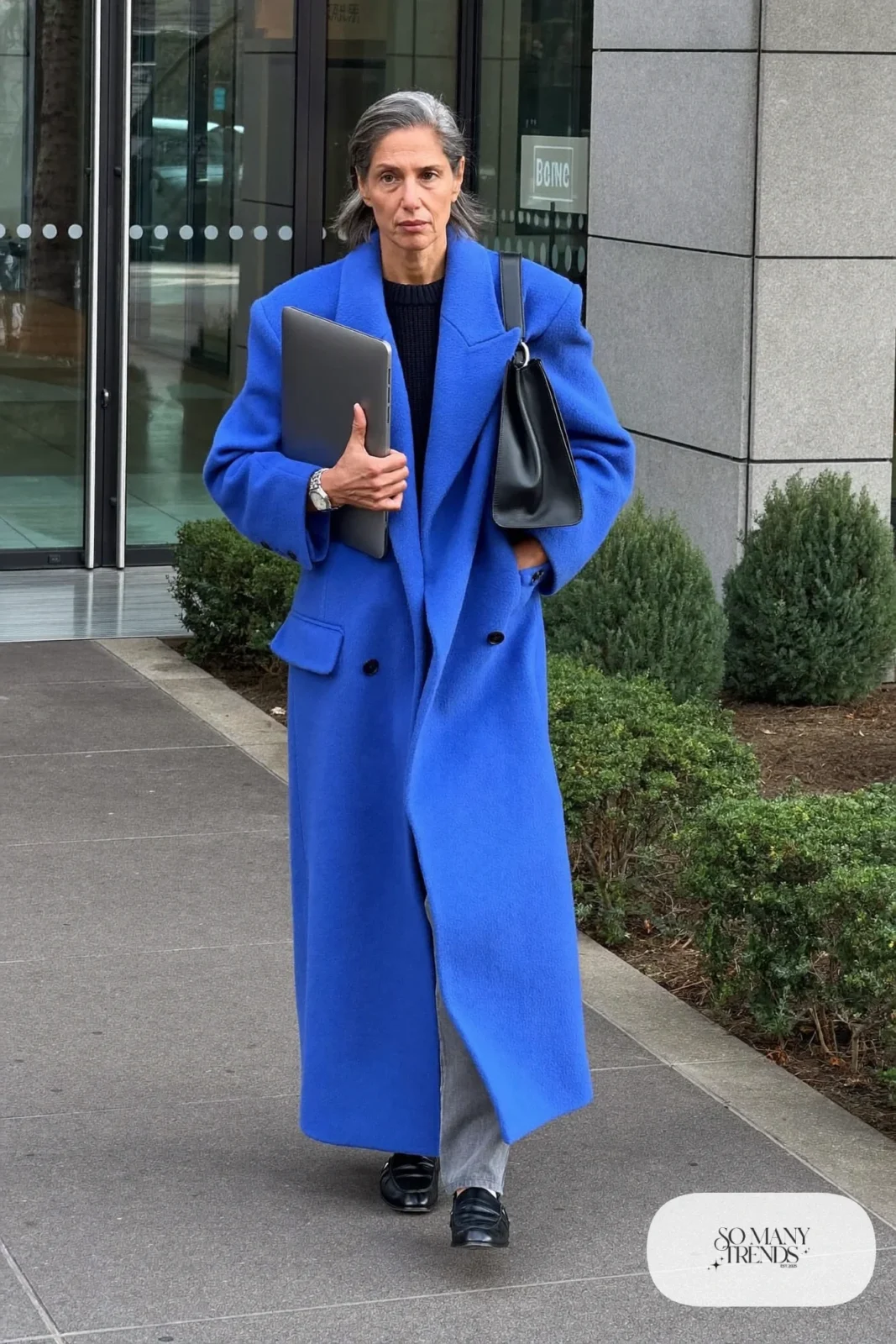 long cobalt blue wool coat gray straight pants black knit sweater black loafers black leather bag silver watch office outfit 34