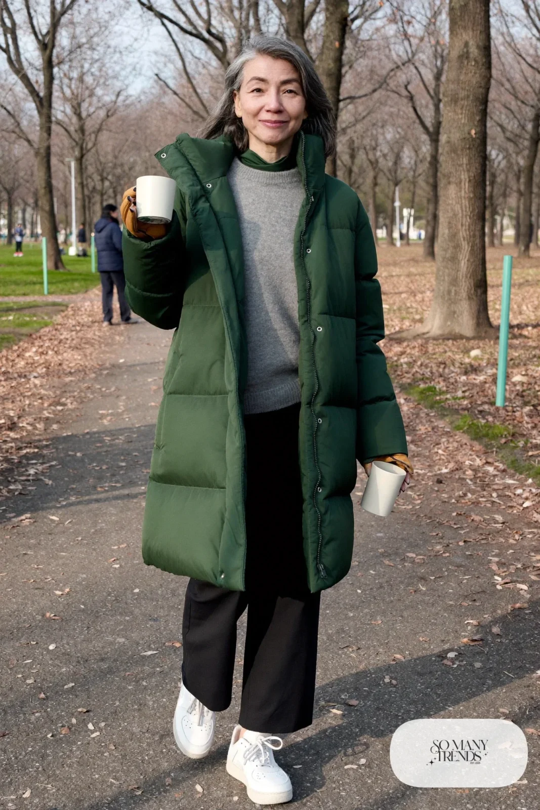 woman over 60 in long forest green puffer coat gray sweater black pants white sneakers gloves outfit 2