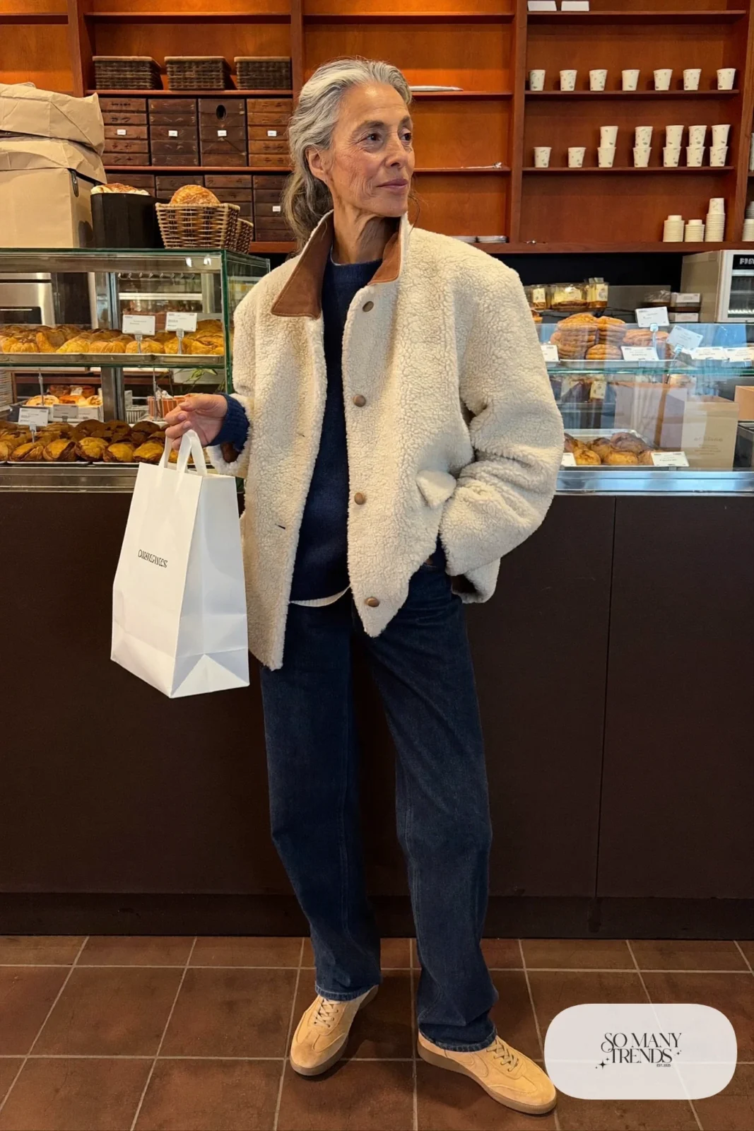 woman over 60 in cream teddy jacket navy sweater dark jeans suede sneakers canvas tote outfit 11