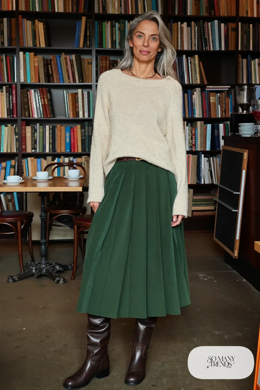 woman over 60 in pleated forest green midi skirt cream sweater half-tucked tall brown boots outfit 18