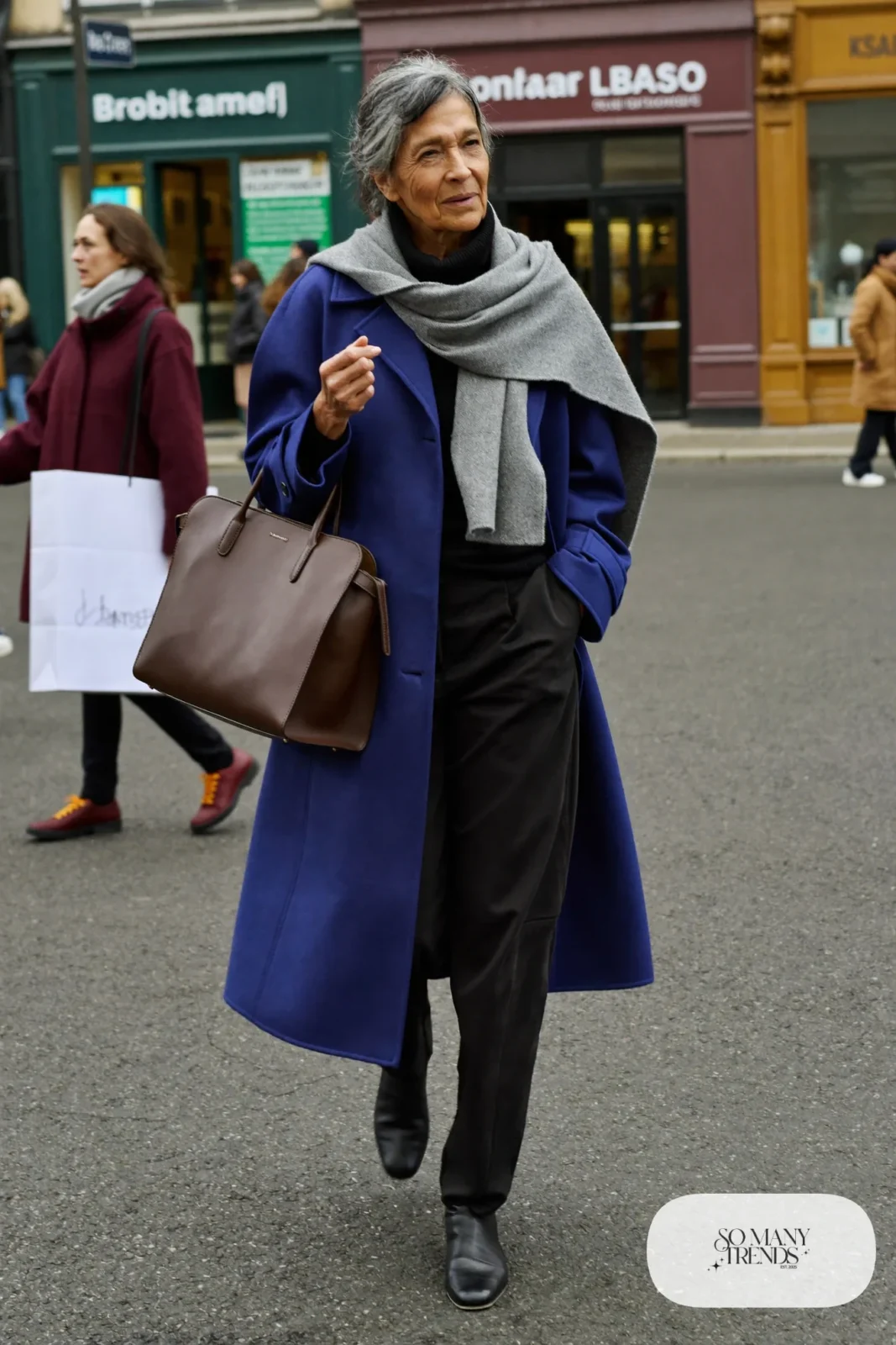 woman over 60 in cobalt blue wool coat black turtleneck black pants black boots gray scarf outfit 19