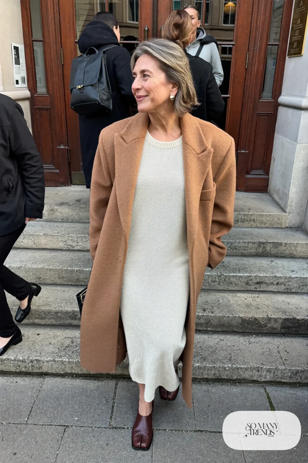 woman over 60 in cream knit midi dress long camel coat block heel shoes pearl earrings outfit 20