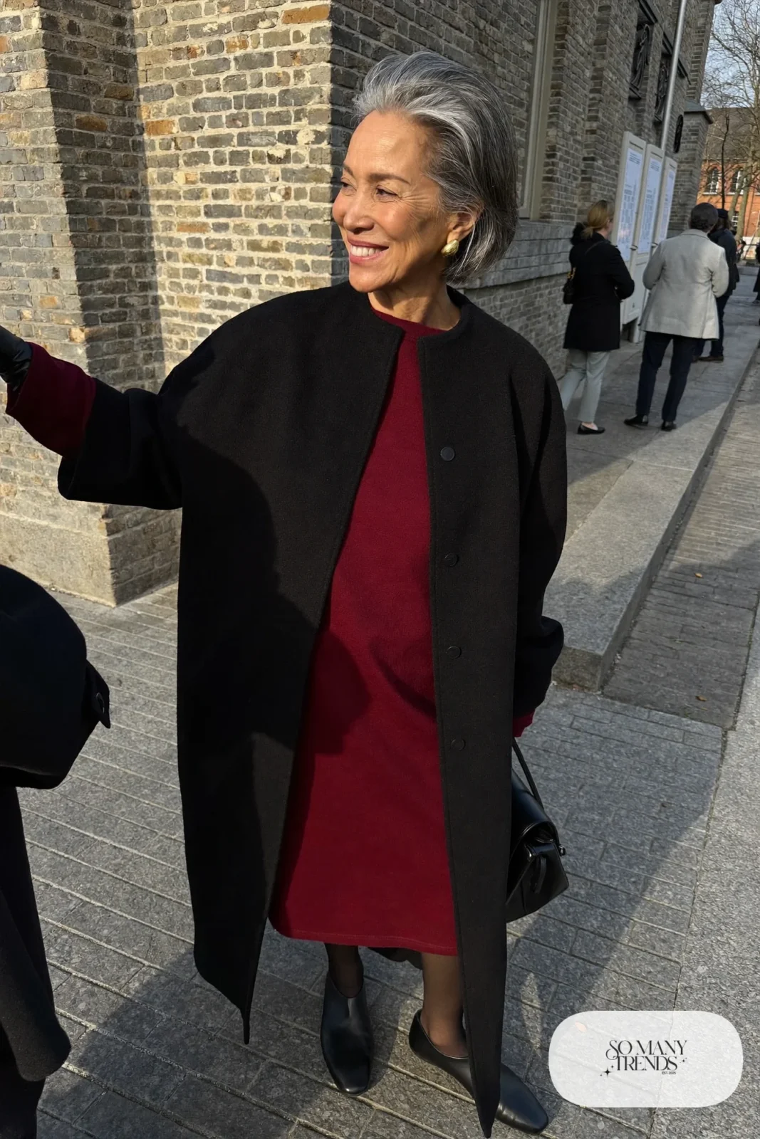 woman over 60 in burgundy midi dress black wool coat black tights black flats outfit 21