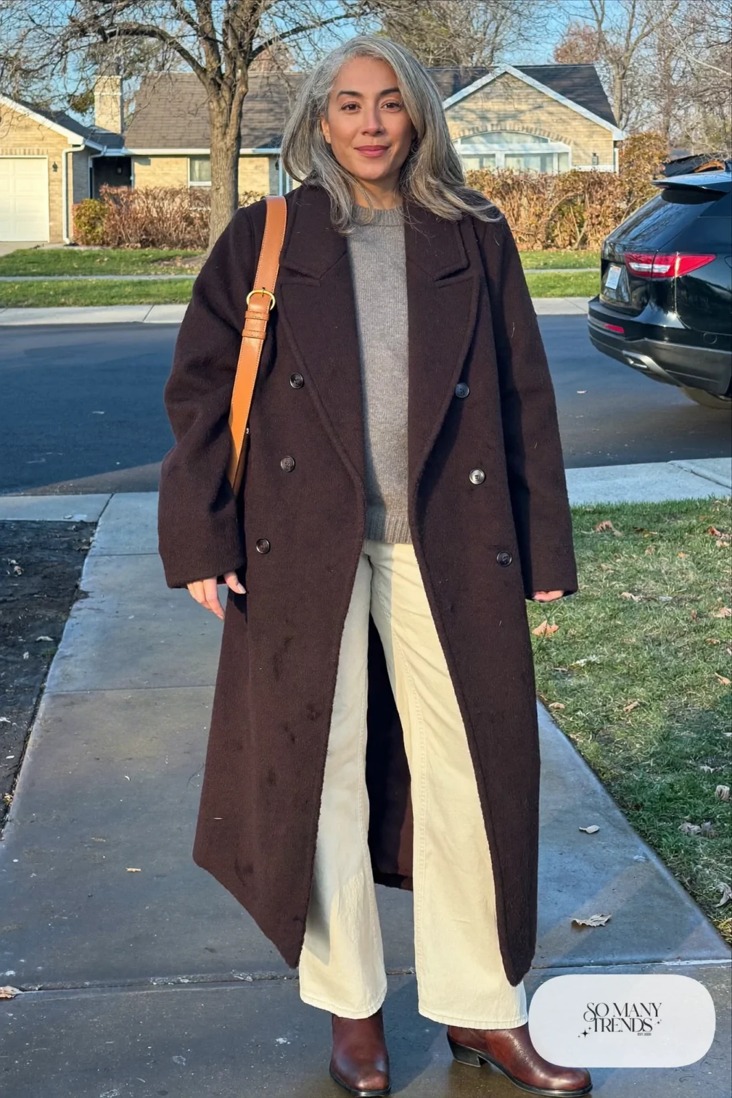 woman over 60 in burgundy wool coat cream wide pants gray sweater brown boots camel bag outfit 26