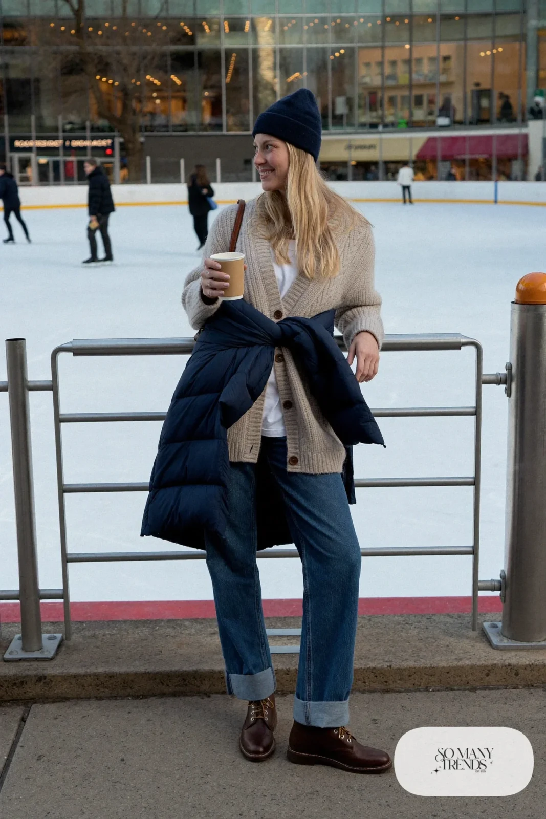 oatmeal chunky wool cardigan white tee straight medium-wash jeans navy puffer coat brown boots beanie outfit 9