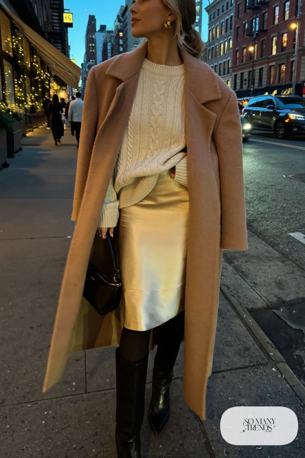 champagne satin midi skirt cream cable-knit sweater tall black boots camel coat gold earrings outfit 21