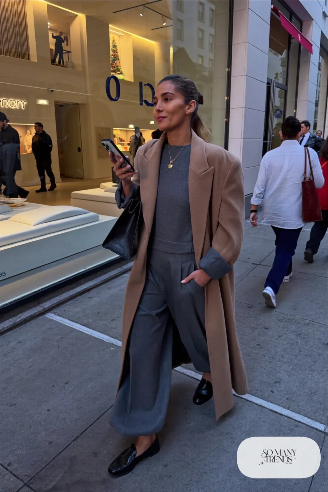 charcoal wide-leg jumpsuit long camel coat black loafers gold necklace office drinks outfit 25
