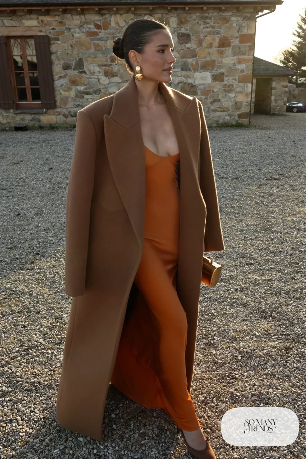 rust satin floor-length gown with long camel wool coat, gold earrings and brown satin heels, formal winter outfit 12