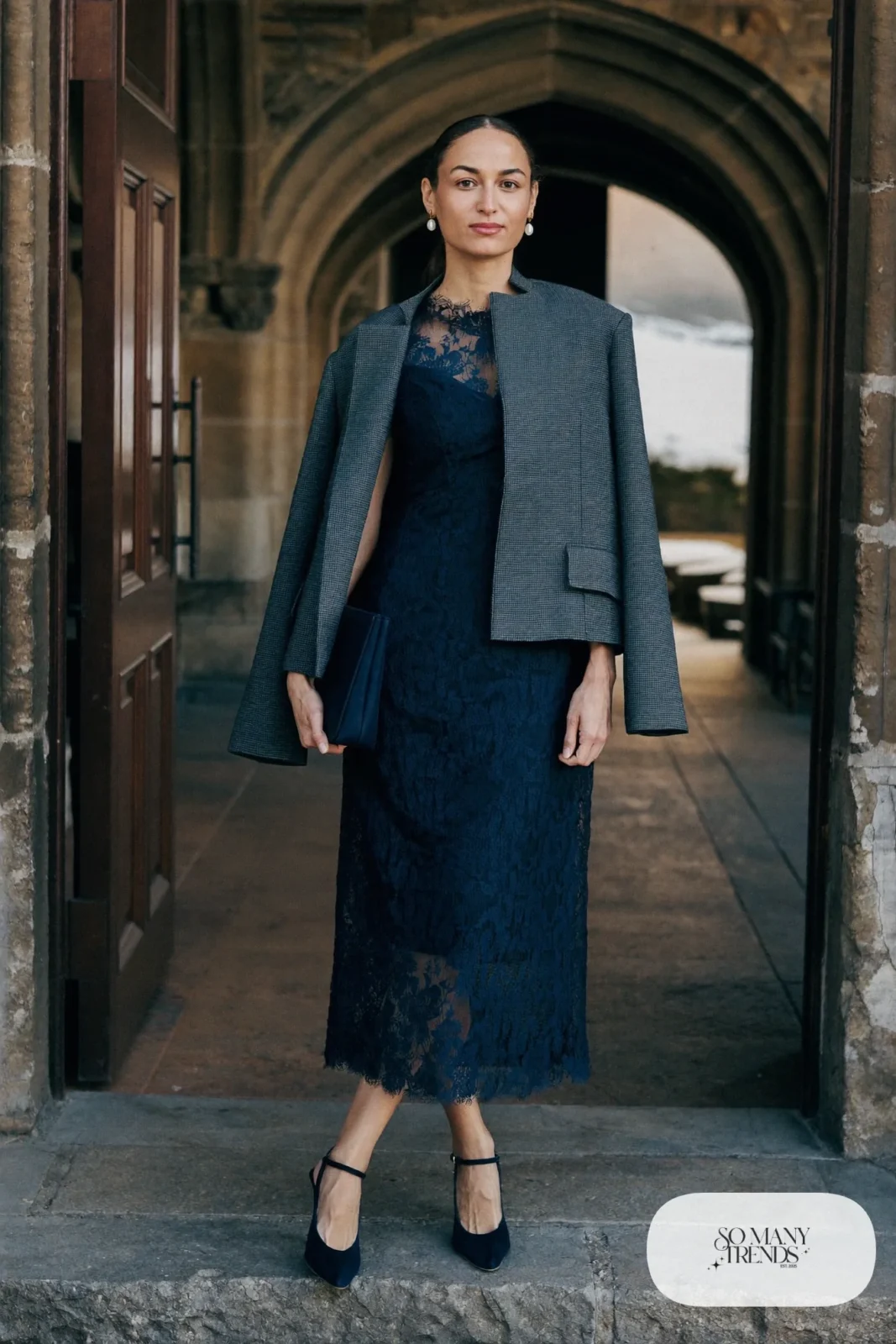 navy lace midi dress with long sleeves and gray tailored wool jacket, closed-toe pumps and pearl earrings, formal winter outfit 20