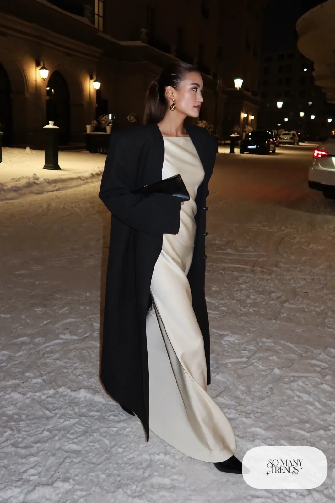 ivory crepe floor-length gown with long black tailored overcoat, gold earrings and black closed-toe heels, formal winter outfit 25