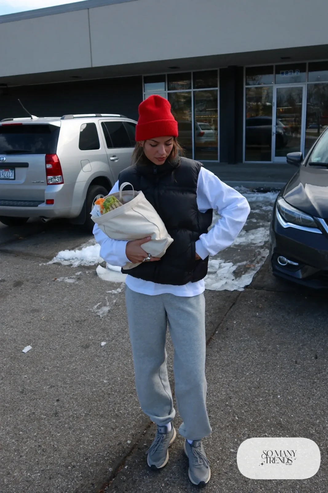 black puffer vest long-sleeve white tee gray joggers gray sneakers cherry red beanie canvas tote january outfit 24