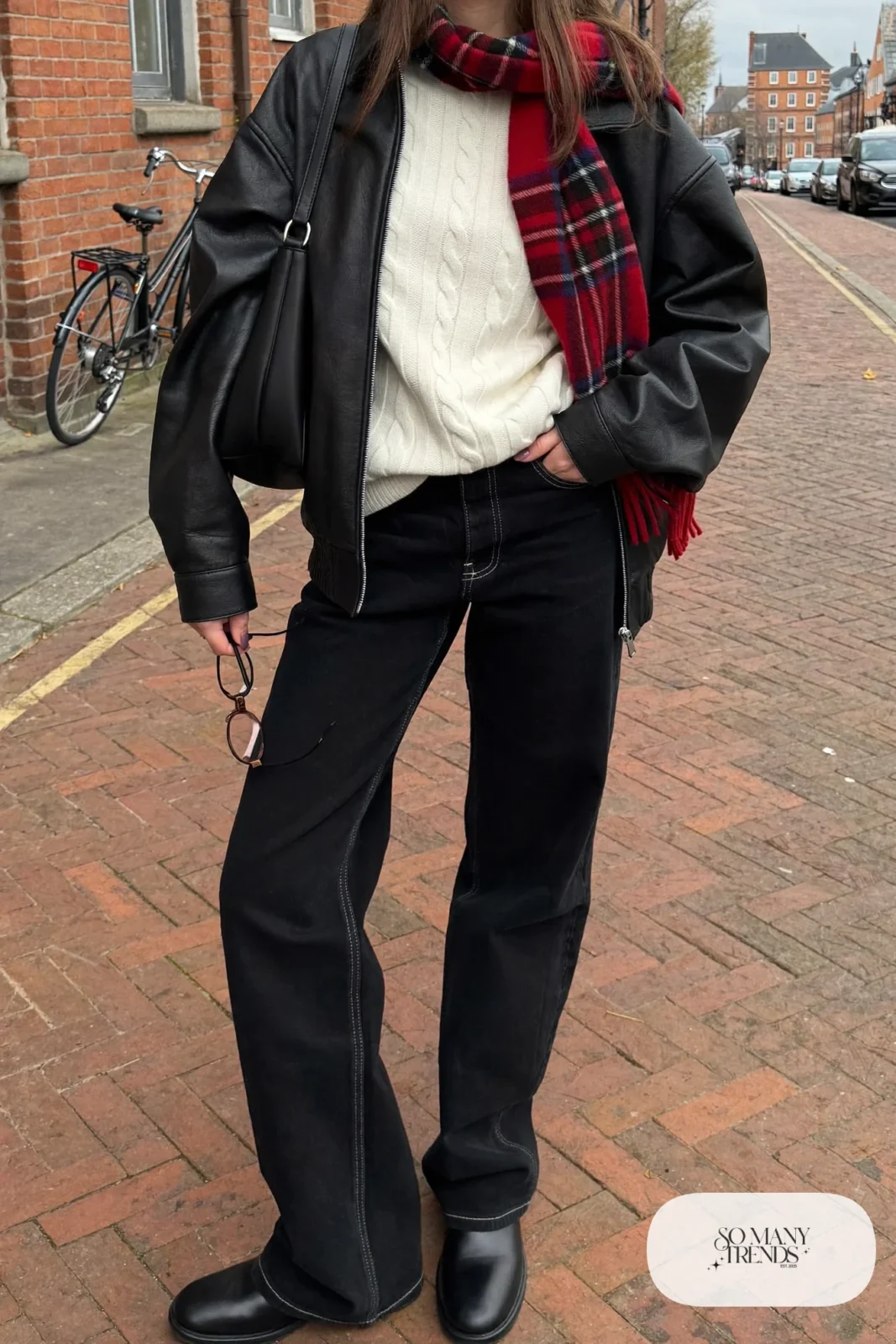 black leather jacket cream cable knit sweater black wide jeans red plaid scarf black boots black bag outfit 17