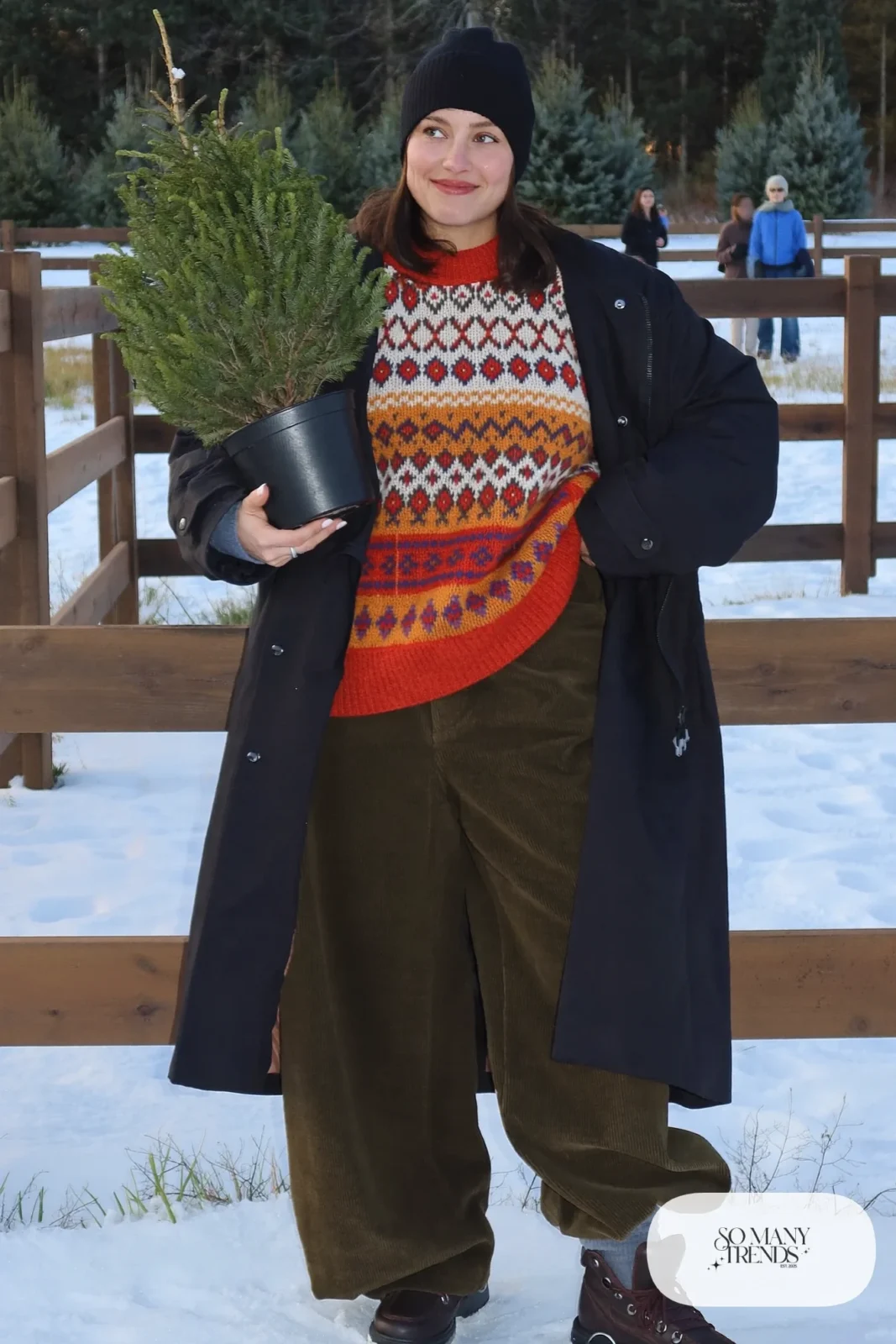black long parka fair isle patterned sweater dark green wide corduroy pants brown boots gray socks plain beanie outfit 19