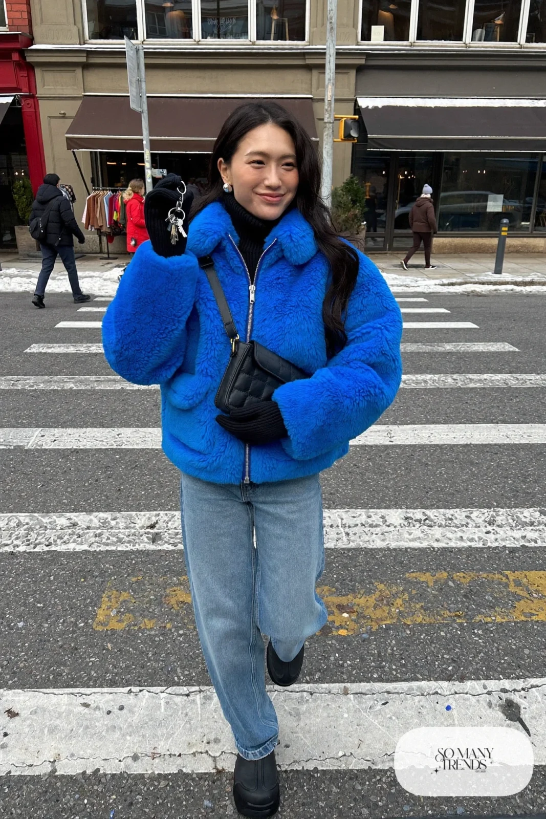 cobalt blue faux shearling jacket black turtleneck straight jeans snow boots crossbody bag outfit 3