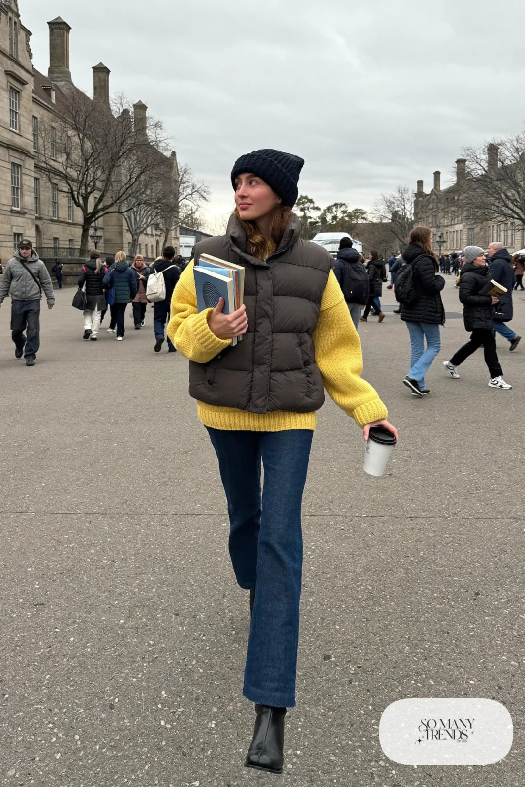 oversized butter yellow knit sweater charcoal puffer vest dark jeans black boots outfit 6
