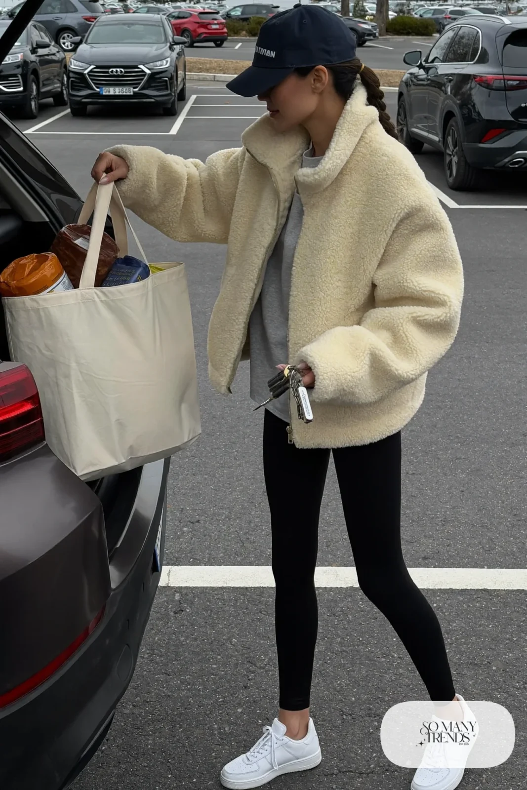 cream sherpa zip-up jacket black leggings white sneakers baseball cap tote bag outfit 25