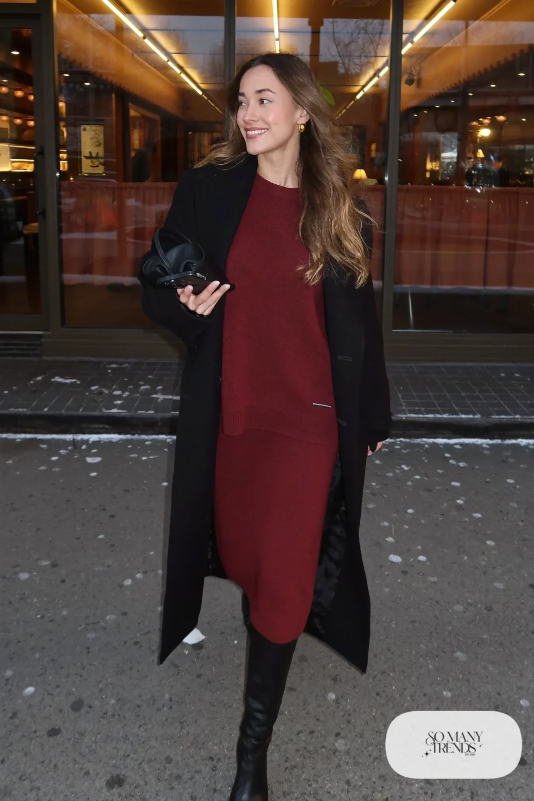 burgundy knit sweater matching midi skirt tall black boots long black coat clutch gold earrings outfit 33