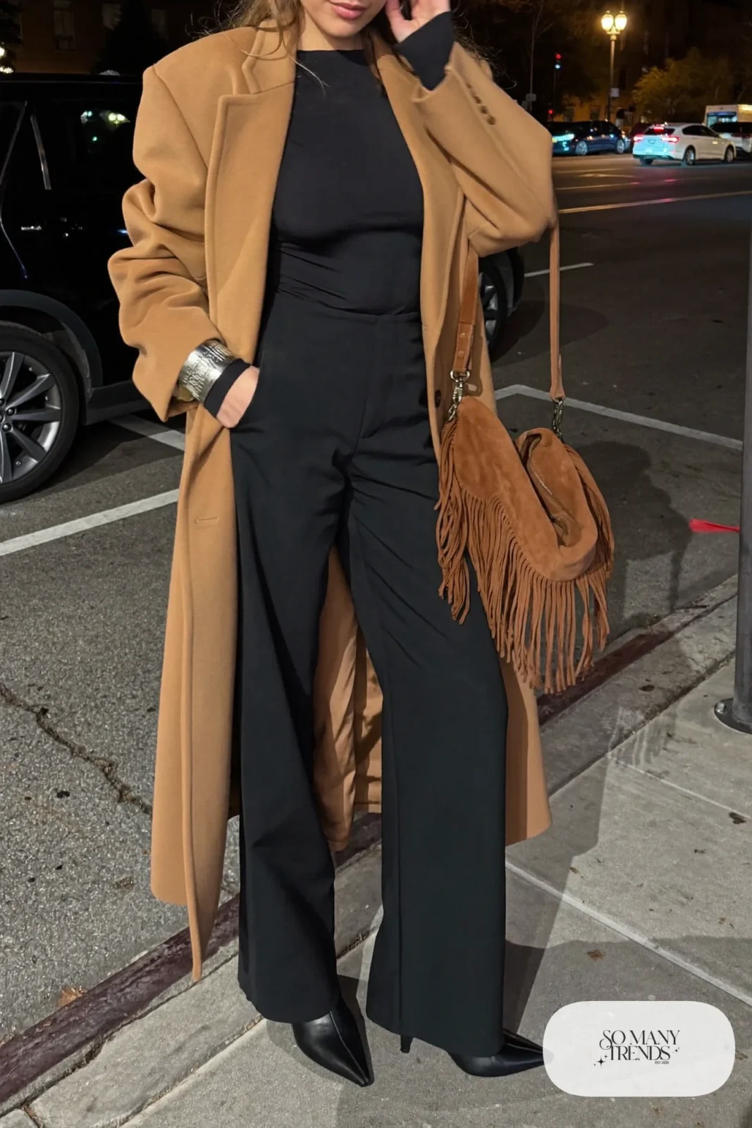 black long sleeve jumpsuit long camel coat fringe bag silver jewelry pointed black boots nashville outfit 17