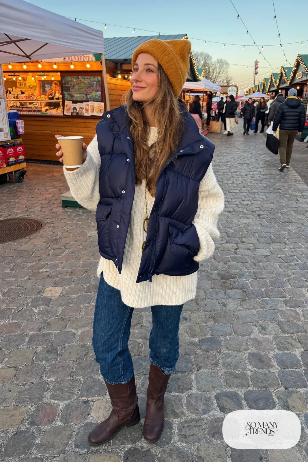 navy puffer vest, cream chunky knit sweater, medium-wash straight jeans, brown boots, beanie outfit 25