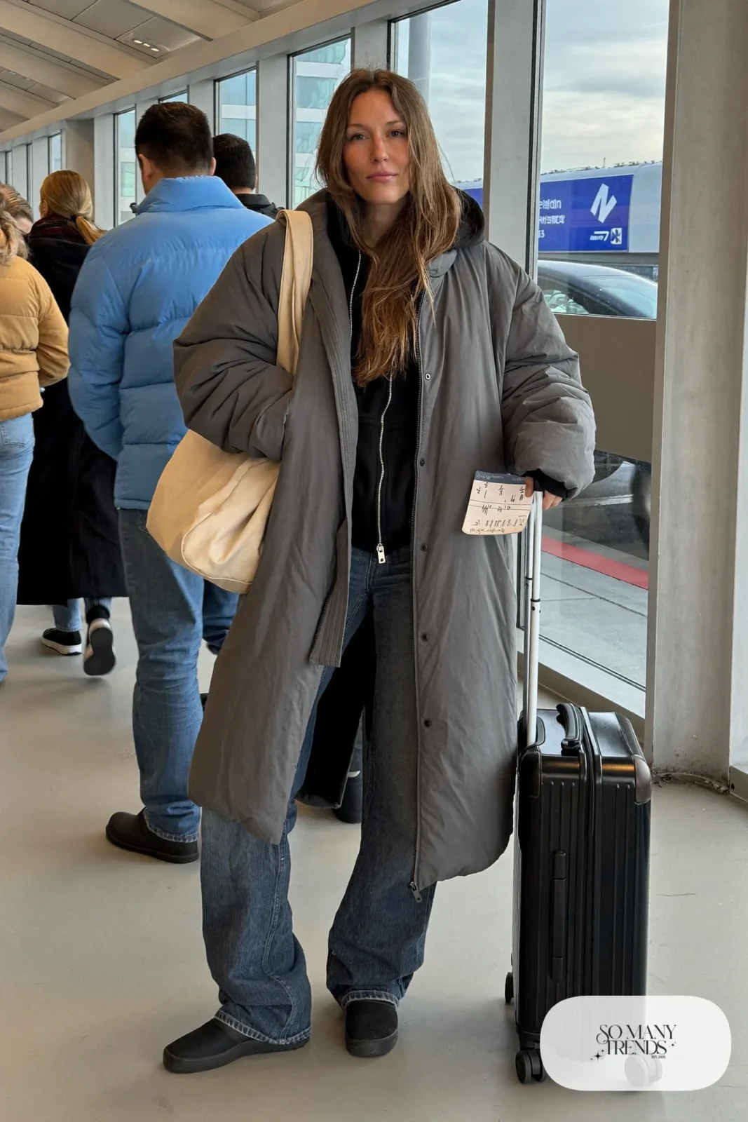 long gray puffer coat, black hoodie, stretch dark jeans, black slip-on sneakers, large tote outfit 29