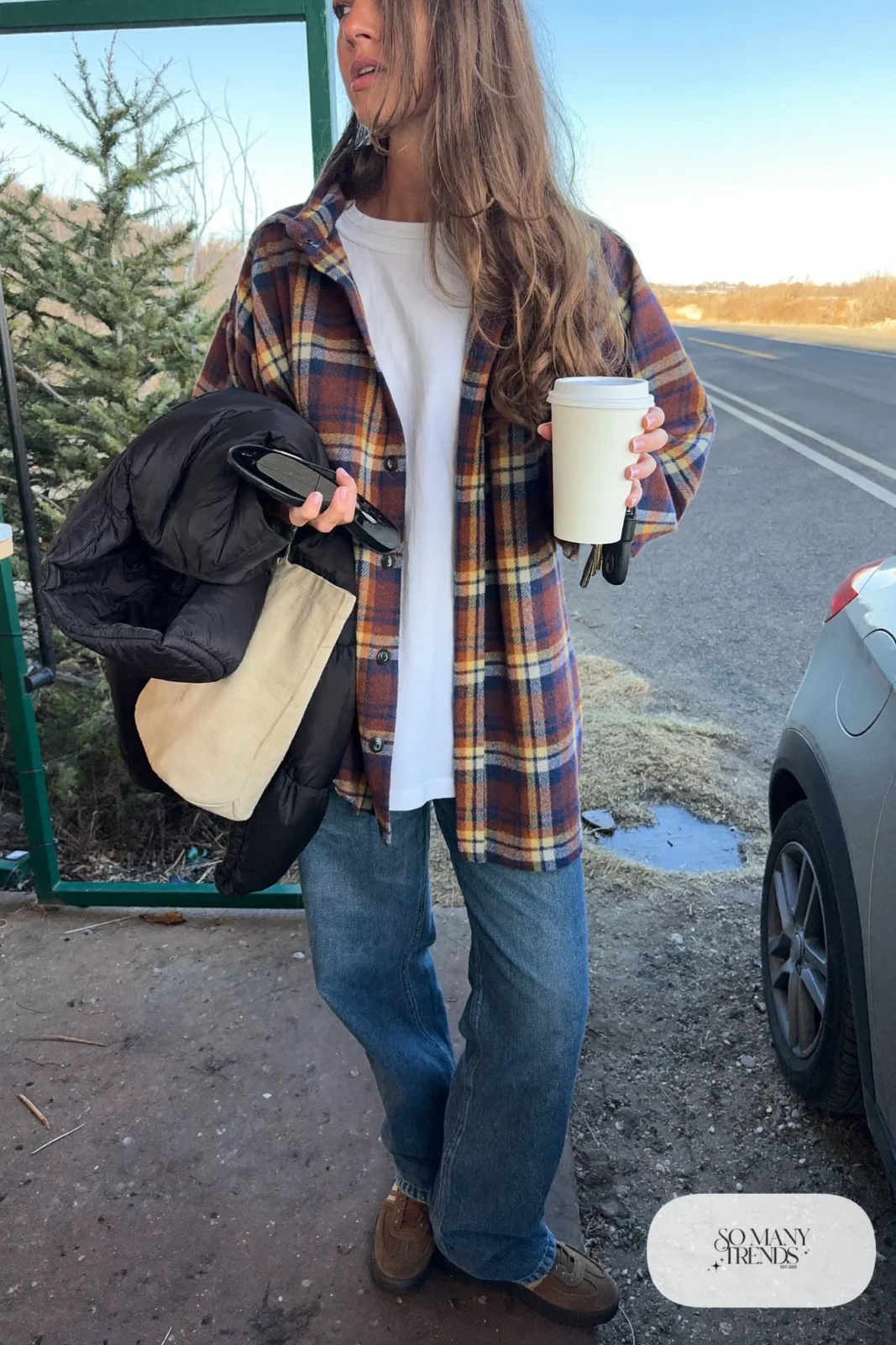 rust flannel shirt, white tee, soft medium-wash jeans, brown leather sneakers, puffer in tote outfit 30