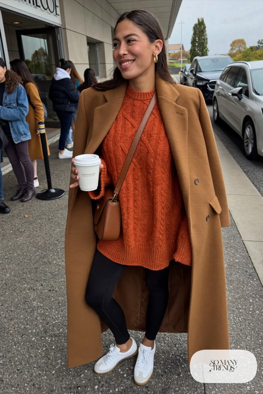 rust cable-knit long sweater black leggings white sneakers camel coat crossbody bag outfit 1