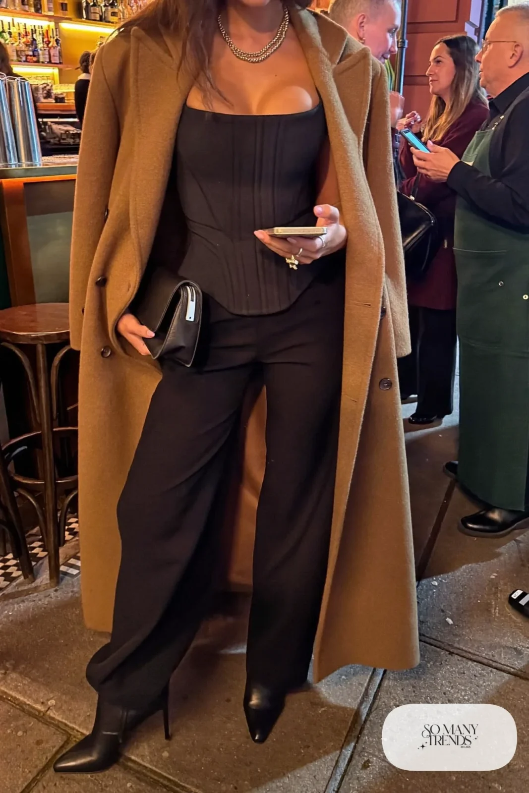 black structured corset top high-waisted wide-leg pants long camel wool coat heeled ankle boots outfit 14
