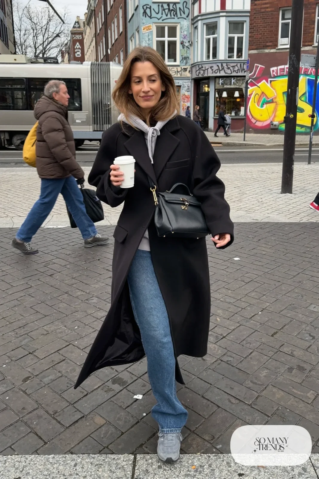 heavy gray hoodie long black wool coat straight blue jeans gray sneakers crossbody bag outfit 30